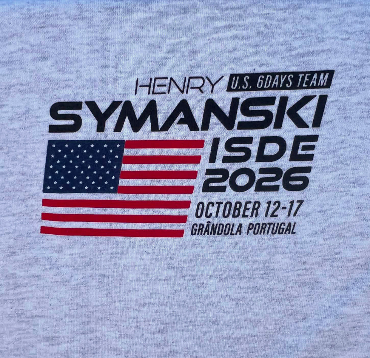 Red and blue United States Flag in ISDE2026 Henry Symanski Logo